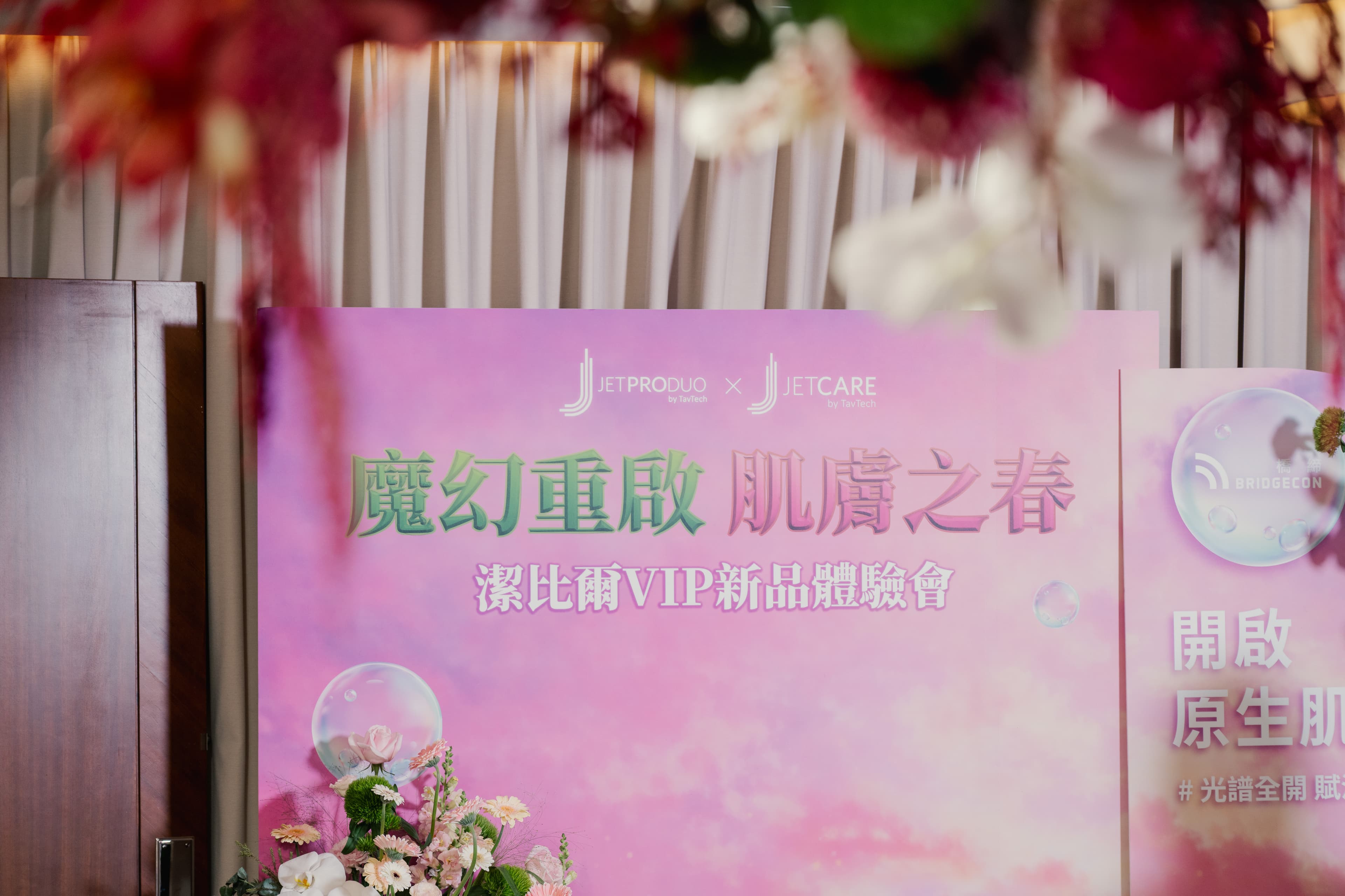 醫美品牌活動軟裝設計_潔比爾JETPEEL品牌主背板近景,精緻花藝裝飾與品牌識別設計